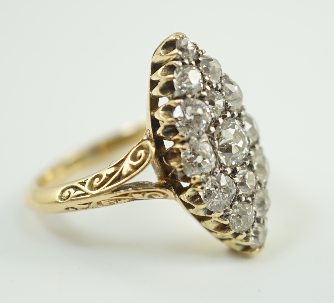 An early to mid 20th century 18ct gold and fifteen stone diamond cluster set marquise shaped ring